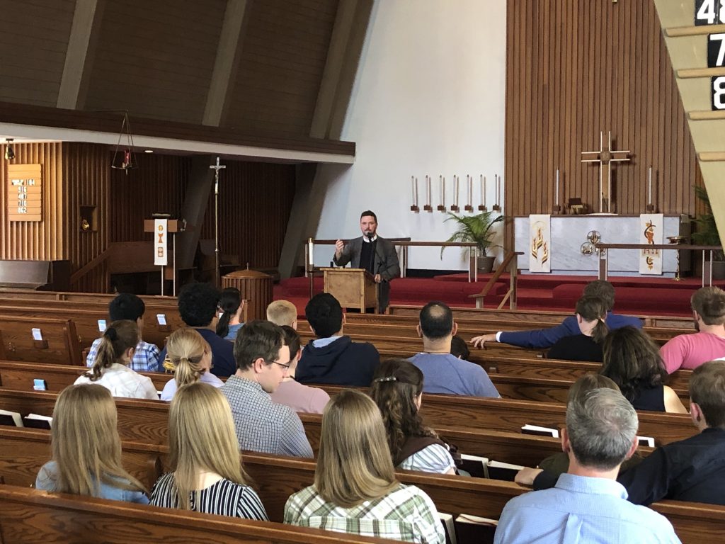 People in pews listen to speaker at a conference on biblical marriage.