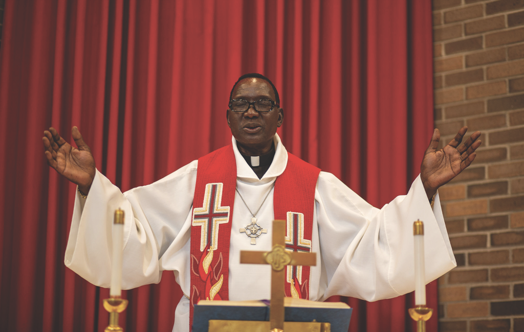 Pastor with outstretched arms at ordination.